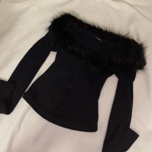 Tröja - En svart ribbad tröja med fake päls. Den är använd ett fåtal gånger. Den har storlek L men jag skulle mer säga S eller XS, den är liten i storleken.                                                                                  Jag har storlek XS.                                                            Frakt tillkommer! 