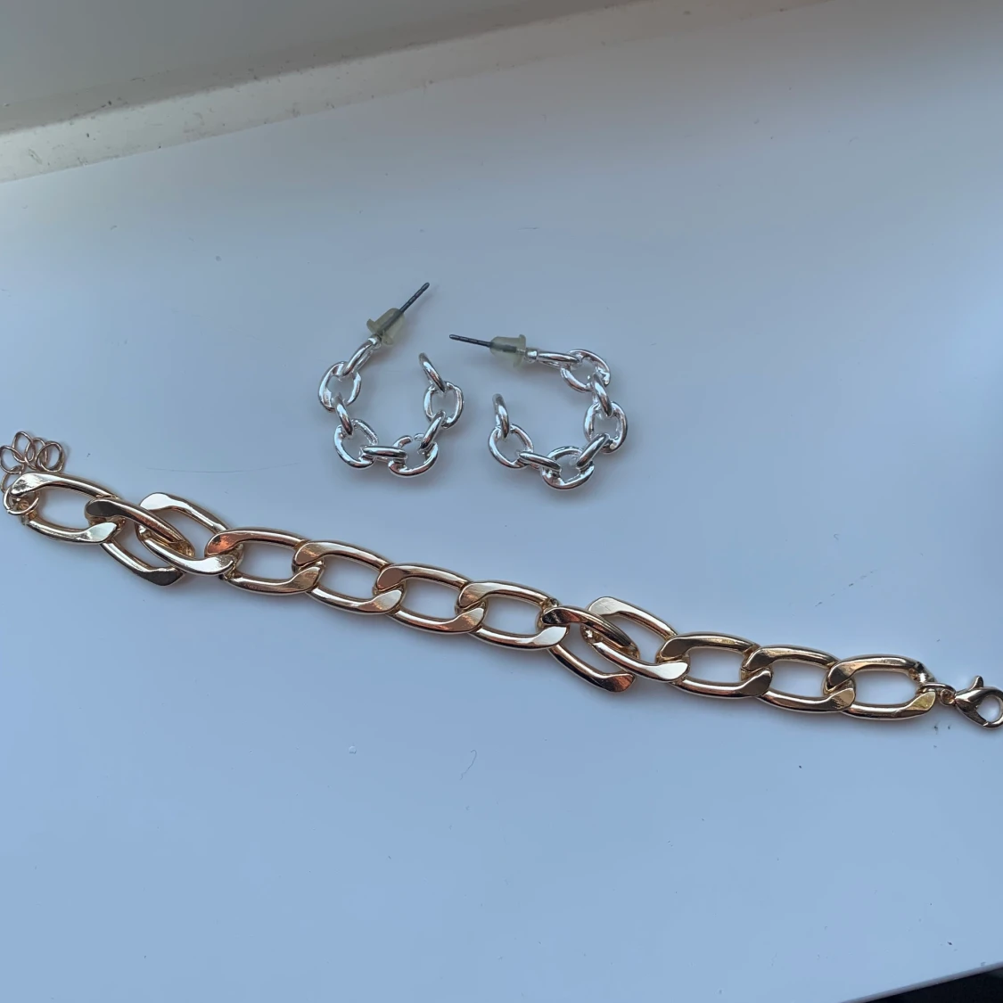 silver örhängen och guldarmband 