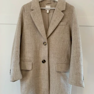Kappa strl xs - Otroligt fin kappa med den perfekta beigea färgen! Tyvärr har kappan ett hål i höger ficka, inget som syns och går lätt att sy igen om det är något som stör! Ett plagg som passar till flera olika tillfällen och definitivt är ett måste i vår 🌷