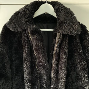 Teddyjacka från H&M - Svart Teddy jacka, som ny, från H&M i storlek s/m. Knappt använd, så jättefint skick! Mjuk och härlig att ha på sig. Stora fina fickor framtill med dragkedja som knäppning. Såldes slut fort! Finns fler bilder att få