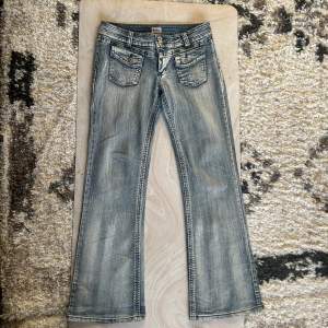 Lågmidjade bootcut y2k jeans med cool design på fickorna 10/10. skick midjemått 41cm rakt över. Innebensläng 81cm