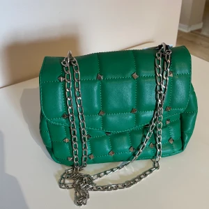 Väska - Cool grön väska med nitar. Har justerbar kedja. Köpt utomlands och helt oanvänd.💕