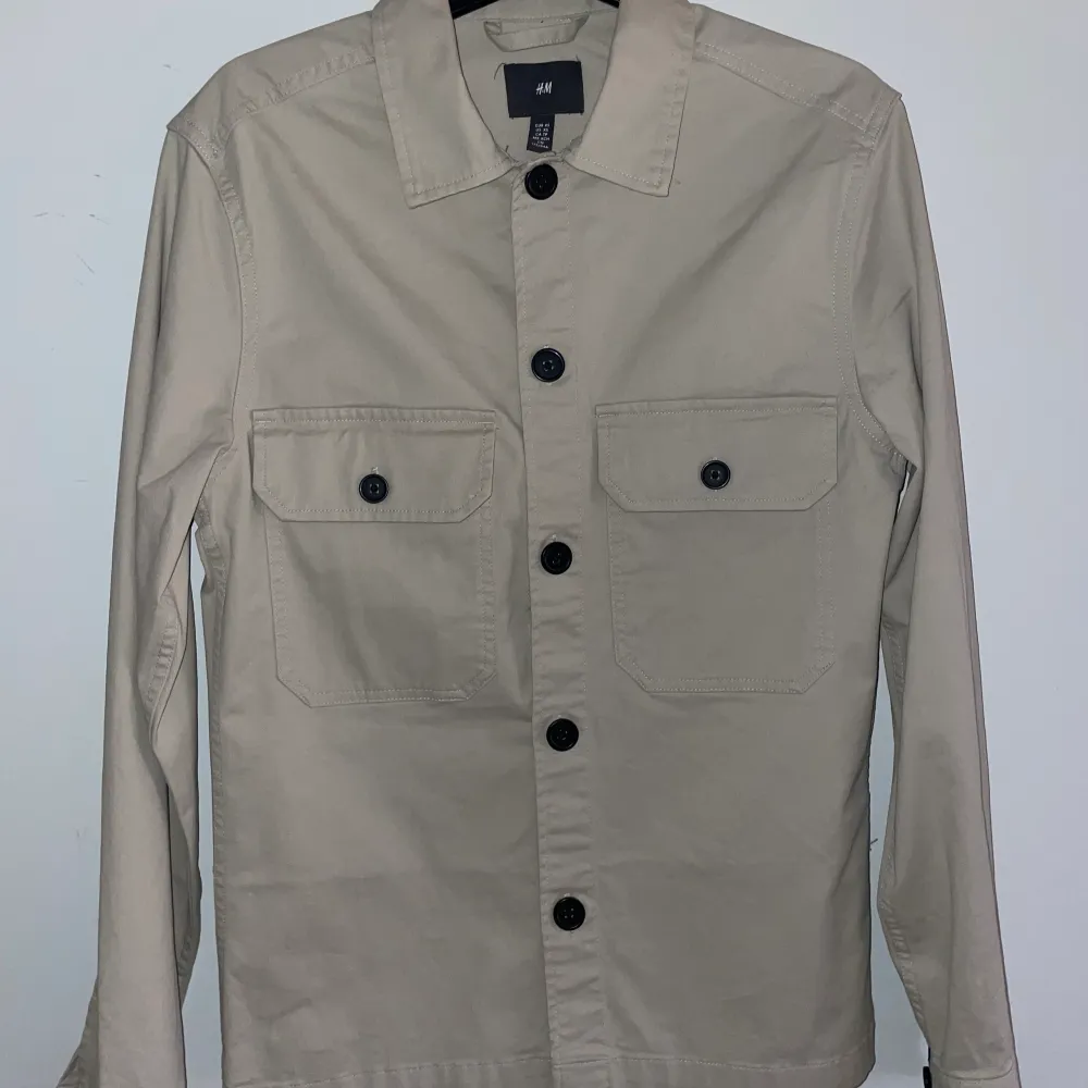 Beige overshirt från hm i storlek XS. Aldrig använd, fick den i present så hann inte lämna tillbaka den. Köparen står för frakten.. Skjortor.