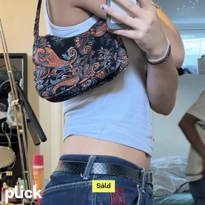 Axelremsväska  - Säljer min coola axelremsväska som tyvärr inte kommer till användning, köpt på Plick därav vet jag inget märke 