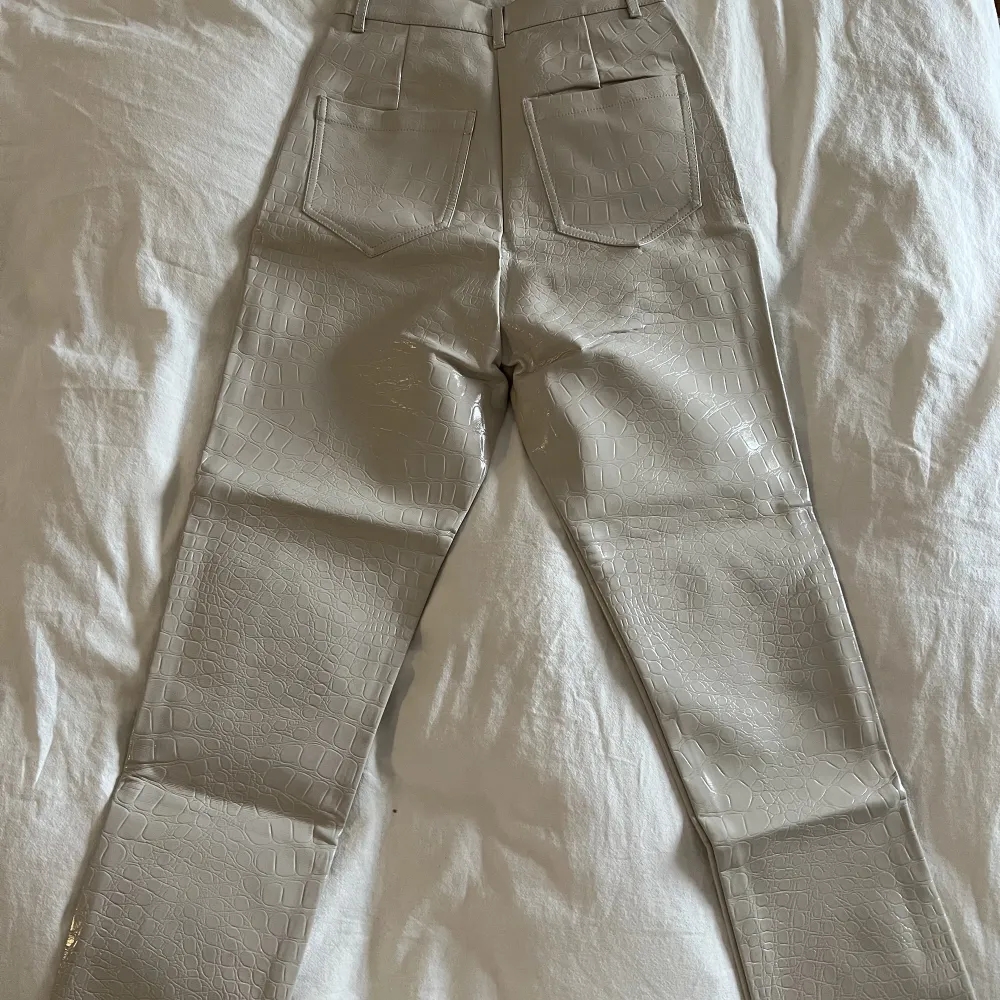 Glansiga ormskinnsbyxor i beige köpta på ASOS. Knappt använda och är i storlek 36. Jeans & Byxor.