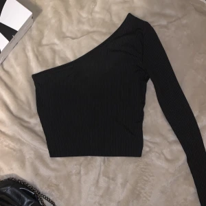 ONE SHOULDER TRÖJA - Svart one shoulder tröja! Den har typ ett randigt ”mönster/material” som syns bättre om man zoomar in på bilden🩵 Köp inom 7 dagar och få fri frakt!🤩