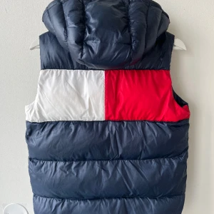 Tommy Hilfiger väst - Säljer en blå Tommy Hilfiger väst storlek 152 jr. Nypris runt 1100 kr. Knappt använd.