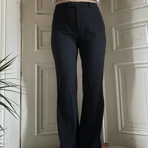 Kritstrecksrandiga kostymbyxor - Randiga byxor med bälteshällor. Vida ben och något långa på mig som är 170cm. 