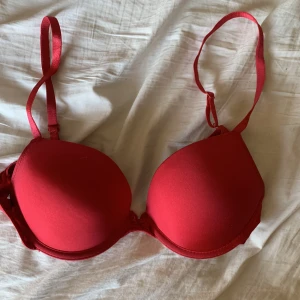 Röd push up bh - Säljer denna söta röda push up bh med en rosett mellan bysten