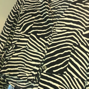 Blus - En vacker blus med zebramönster och knappar framtill. 