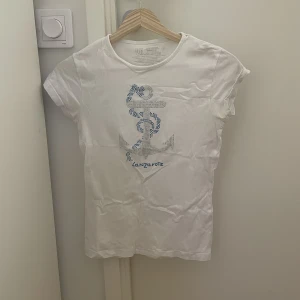 T-shirt med tryck - Fin t-shorts med fint tryck av strass. Fin till sommaren med kjol t.ex. storlek S, skriv privat för frågor!