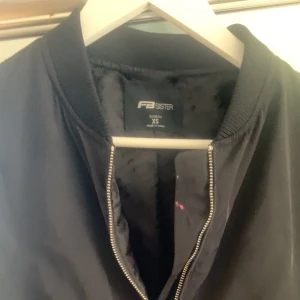 Tunn jacka - Tunna jacka med silver detaljer.  En liten fläck på insidan av jackan, (se bild)