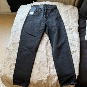 Dr denim jeans modell Nora mom jeans med hög midja i tvättad svart färg. W 25, L 30. Helt nya med taggen på.