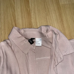 Skjorta  - Skjorta i gammalrosa färg. Lätt tyg till sommaren. Aldrig använd. 