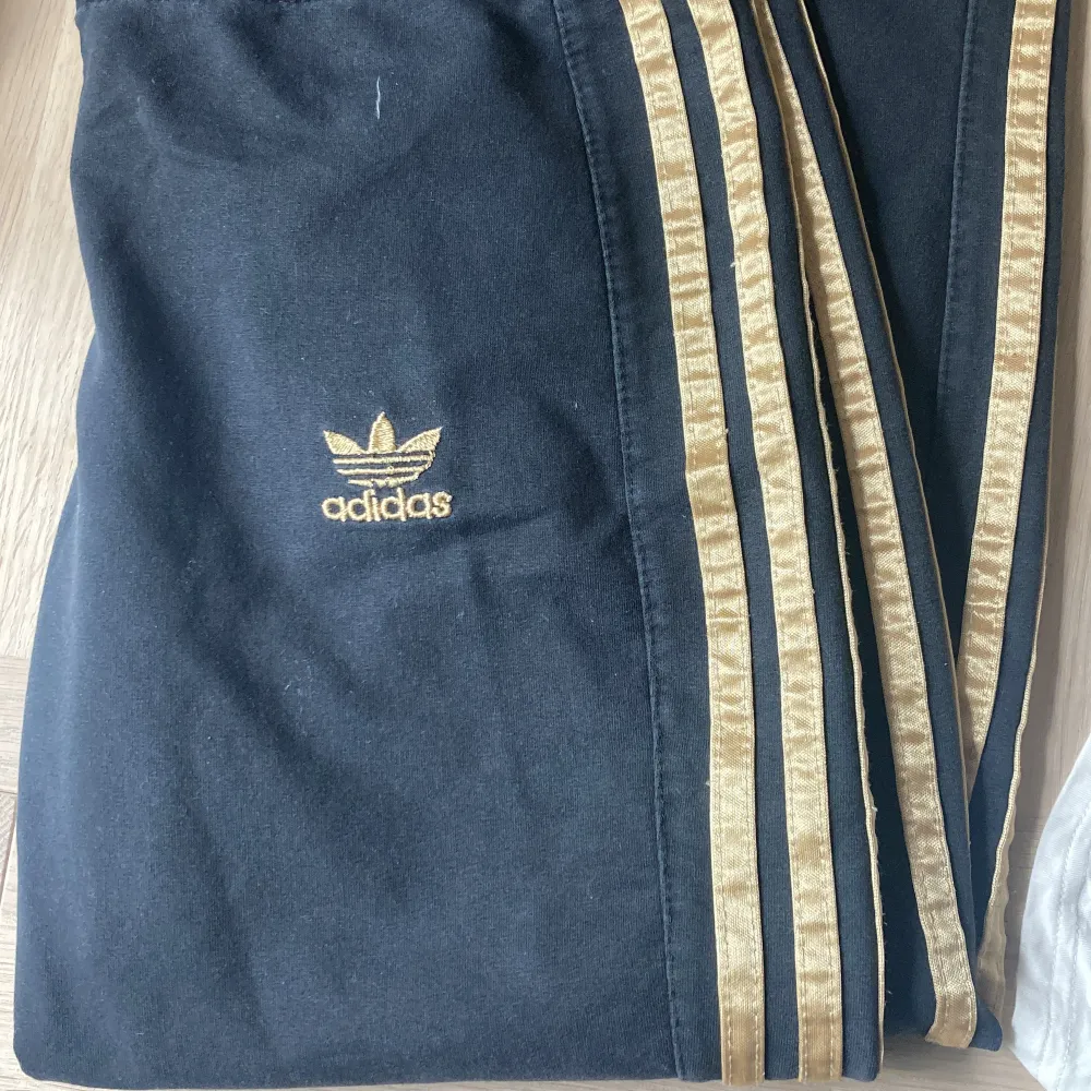 Adidasbyxor med guldiga stripes, straight fit typ.. Jeans & Byxor.