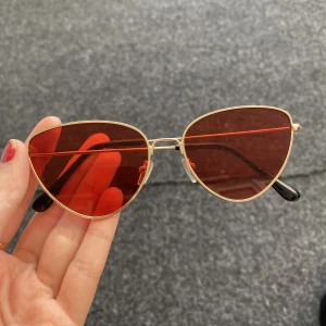 Skitcoola solglasögon med rött glas!😌 - Säljer dessa solglasögon med guldiga kanter och rött glas då jag inte använder dom! I väldigt gott skick då jag aldrig använt dem utan endast provat.  