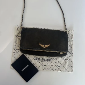 Zadig Voltaire väska  - Högsta bud 900kr .                                      Mörkbrun/svart mocka väska från zadig Voltaire. Väl använd men fortfarande bra skick. Äkta, påse och kvitto medföljer. Nypris cirka 3000kr.   Säljer för 650kr eller bud ifall många är intresserade