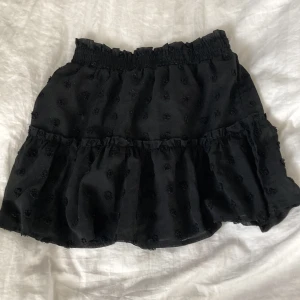 Svart kjol - En kort svart volangkjol