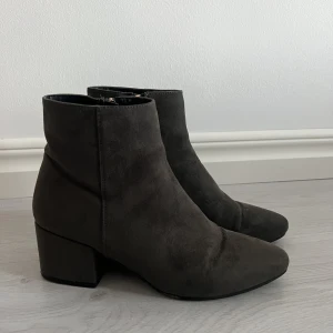 Stövletter - Stövletter i grå mockaimitation, använd några fåtalet gånger men är fortfarande i fint skick. Dessa från XIT är i strl 39 med dragkedja på insidan.