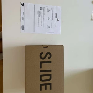 Yeezy Slide Azure/Blå - Helt nya blåa yeezy slides. Storlek 43 men passar storlek 42. Köpta på adidas appen. Oanvända. Frågor? Skriv till mig :)