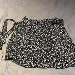 Kjol - Säljer en jättefin blommig omlott kjol med snörning, aldrig använd så i nyskick💗 skriv för fler bilder!