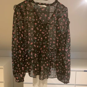 Blus - En svart och blommig blus