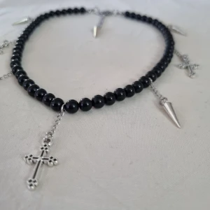 Pärlhalsband med nitar och kors - Helt i rostfritt stål förutom pärlor, charms och nitar! Nitar är i zink så kommer inte tappa färg. Mitt mål är att mina halsband ska hålla i flera år så jag satsar på att göra allt i rostfritt/kirurgiskt stål. 