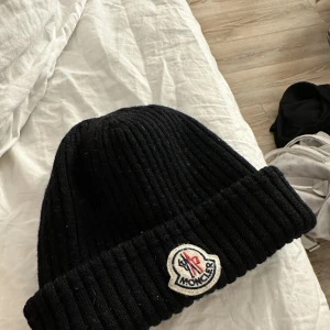 Moncler mössa  - Svart mössa från moncler säljer billigt då den ej används och vill bli av med den snabbt. 