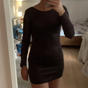 Festklänning - Figursydd festklänning i glitter. Använd endast en gång så den är i nytt skick. Färgen gör sig rättvis på sista bilden. Strl. 38