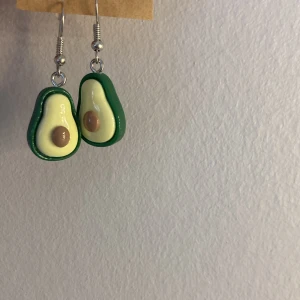 Örhängen - 3 st par örhängen. Ett par bananer med guld krokar. Ett par avokados med silver krokar. Och ett par klubbor med guld krokar. 