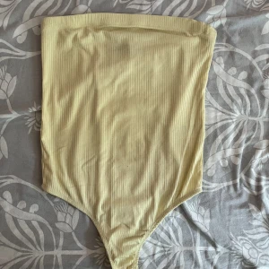 Body - Gul bandeau body från bikbok, använd men i bra skick.
