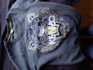 Kenzo Crewneck Guld och Grå - En fin tröja som tyvärr blivit något för liten sedan ett tag tillbaka, är M i storleken men sitter snarare som en S. Nypris:2200:- Fler bilder skickas gärna på förfrågan.
