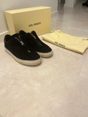 Axel Arigato zip - Säljer nu mina arigatos då dom ej kommer till användning. Dom är använda men fortfarande mycket liv kvar att hämta, med en tvätt kan dom bli ännu fräschare! Låda, dustbag och kvitto från NK tillkommer! Pris kan disskuteras vid snabb affär!