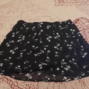 Sommar kjol - Svart och blommig kjol. Rätt kort runt hela men väldigt fin och skön på sommaren. 