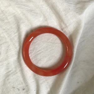 Röd orange swirl jade armring - Ramlar inte av men går att få på ganska enkelt, skulle nog passa på folk med större händer också om du trycker på