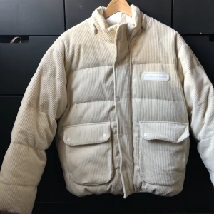 Höst/vinterjacka  - Vändbar Jacka från ”the museum visitor”. Beige sida och även en vit sida med tryck på ryggen. Väl fodrad och både dragkedja samt knappar. Aldrig använd.  Pris går att diskutera. 