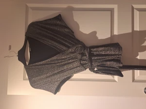 Blus - Glittrig blus från Bik Bok, använd en gång, stl S. Med knytband runt om midjan