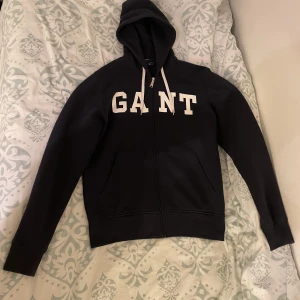 Gant Blå Zip hoodie - En blå Gant zip hoodie i väldigt bra skick. Storlek L men Passar M också lite kortare i midjan