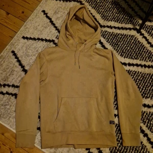 Jack & Jones  - En ljusbrun hoodie från Jack & Jones som passar både till dig som har Small eller Medium. Är i ett bra skick, Storlek S. 