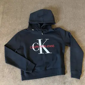 Säljer min Calvin Klein hoodie. Den är svart med rött och vitt tryck på magen. Använd sällan. Säljer då den inte kommer till användning. 