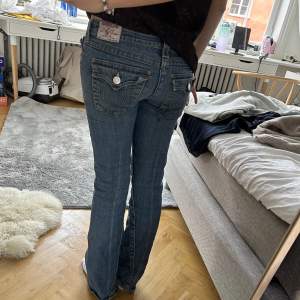Lågmidjade mörkblåa true religon jeans. Sjukt snygga, lite slitna på benen annars bra skick! Har vanligtvis strl 36/38 i zara jeans!! Innebenlängd: 84cm och mått direkt över midja är 38💕
