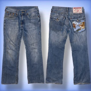 True Religion Jeans - Ett par sjukt unika True Religion jeans med en fet inbroderad bild på högra bakfickan! Kolla sista bilden för tydligare! Hör av dig om du har frågor!