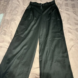 Lichi kostymbyxor - Kostymbyxor från Lichi, vida i benen (mer bilder kan fås vid intresse). Aldrig använda med lappen kvar. Dvs nyskick. Säljes till förmånligt pris, något korta på mig som är 177cm lång!