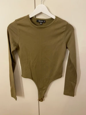 Grön body.  - Hej, säljer denna fina body. Använts en gång. Är i jättefin skick. Skön mot huden och värm att ha nu på hösten. 
