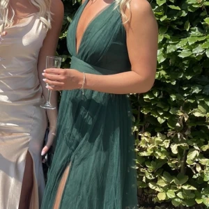 Balklänning  - Jättefin mörkgrön balklänning som endast är använd vid 1 tillfälle. Klänningen har en slit på benet och går en bit ner på marken, är 168 cm lång. 