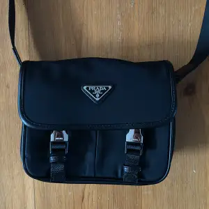 1:1 Prada väska. Kommer med tillbehör som liten väska och ett Prada kort. Även massa små detaljer på väskan. Inprincip oanvänd 9/10. Vid snabb affär kan vi förhandla om pris