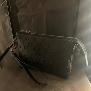 En elegant Gucci väska som jag skulle kalla en unisex väska som du både kan ha som en hand väska och axelväska, till kommer även med band.