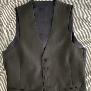 En mörkgrå/navy kostymväst från Ted Baker. Aldrig använd. Storlek M. 