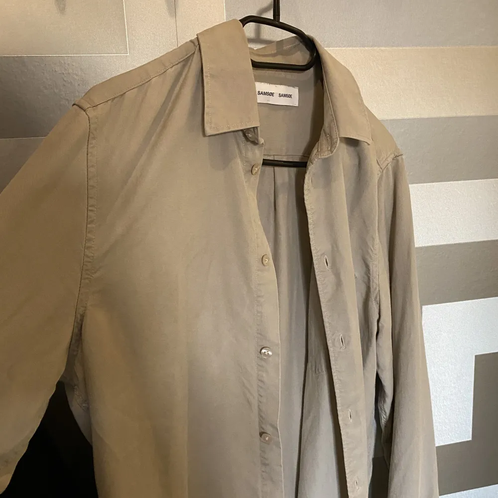 Snygg beige Samsøe skjorta, använd skick 9/10.   Material 100% lyocell, vilket är ett extremt mjukt material och skapar fint fall på skjortan.  Säljs pga garderobsrensning då denna inte längre används  Köpt för 1100kr. Skjortor.