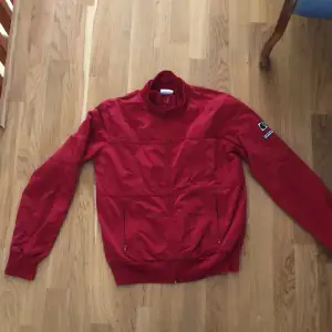 Röd tröja med dragkedja från Carhartt. Storlek medium för dam.